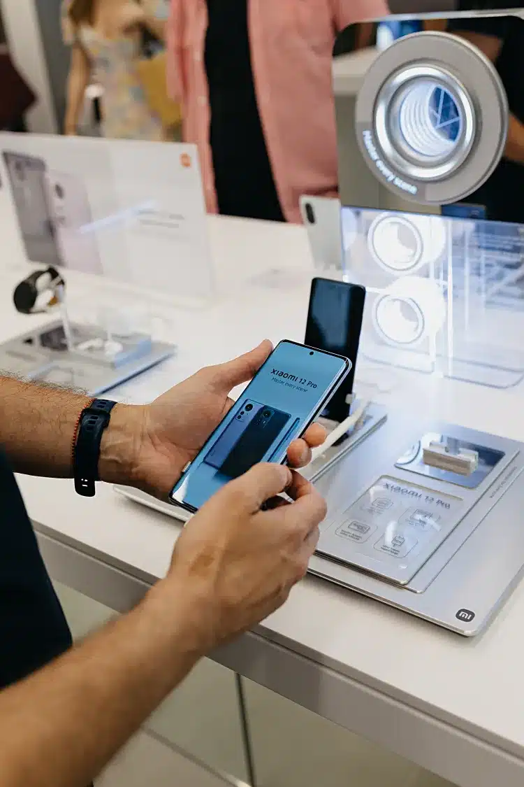 Ο Στάθης Ασπιώτης περιεργάζεται ένα Xiaomi 12 Pro σε προθήκη του ανανεωμένου Xiaomi Store στο Golden Hall