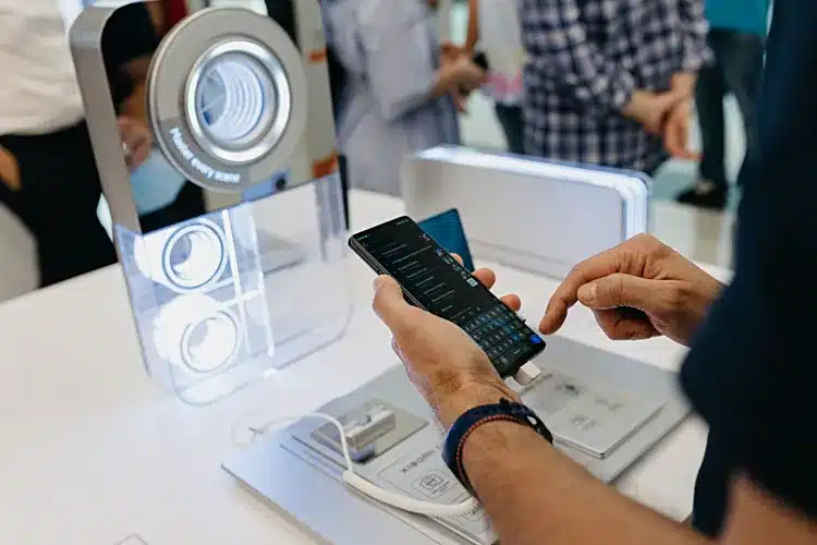 Ο Στάθης Ασπιώτης περιεργάζεται ένα Xiaomi 12 Pro σε προθήκη του ανανεωμένου Xiaomi Store στο Golden Hall